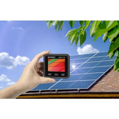 Jedna ruka drži uređaj s zaslonom ispred solarnih ćelija na krovu za sunčanog vremena. Uređaj prikazuje šarene stupce.