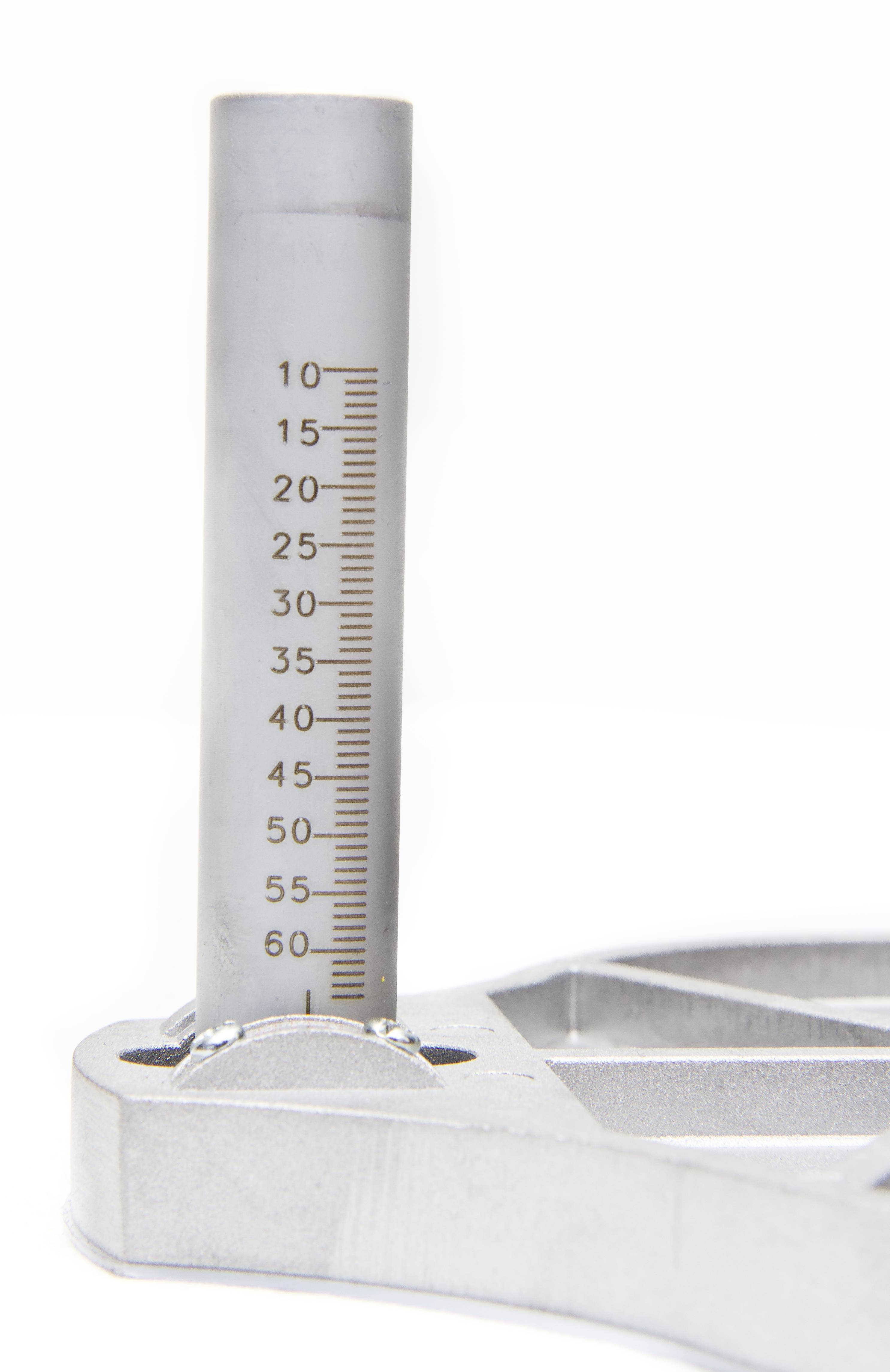 Srebrna cijev s mjernom skalom od 0 do 60 prikazuje mjerne vrijednosti. Cijev je montirana na srebrnom postolju.