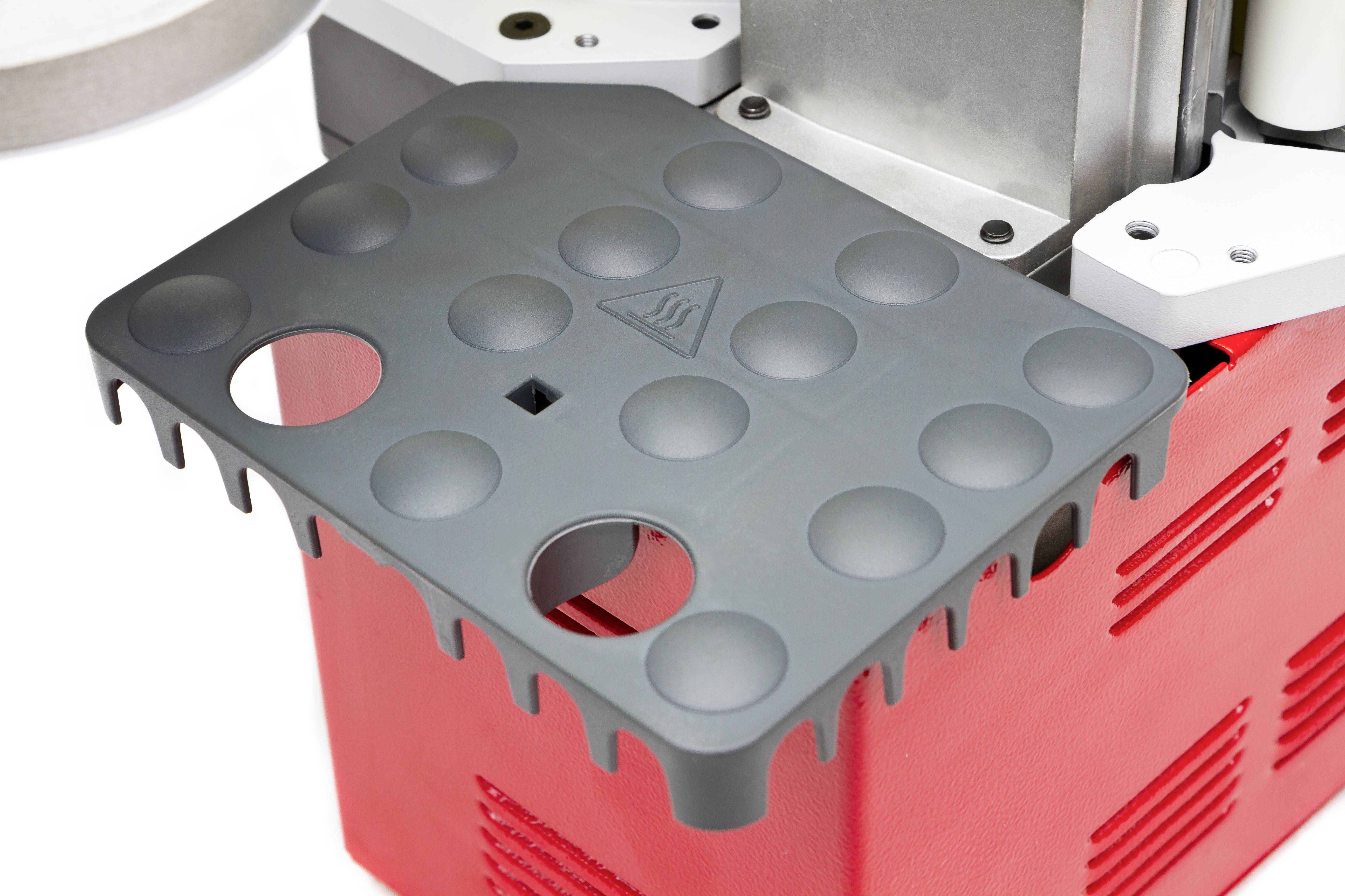 Uređaj crveno-crne boje s perforiranom sivom pločom na vrhu.