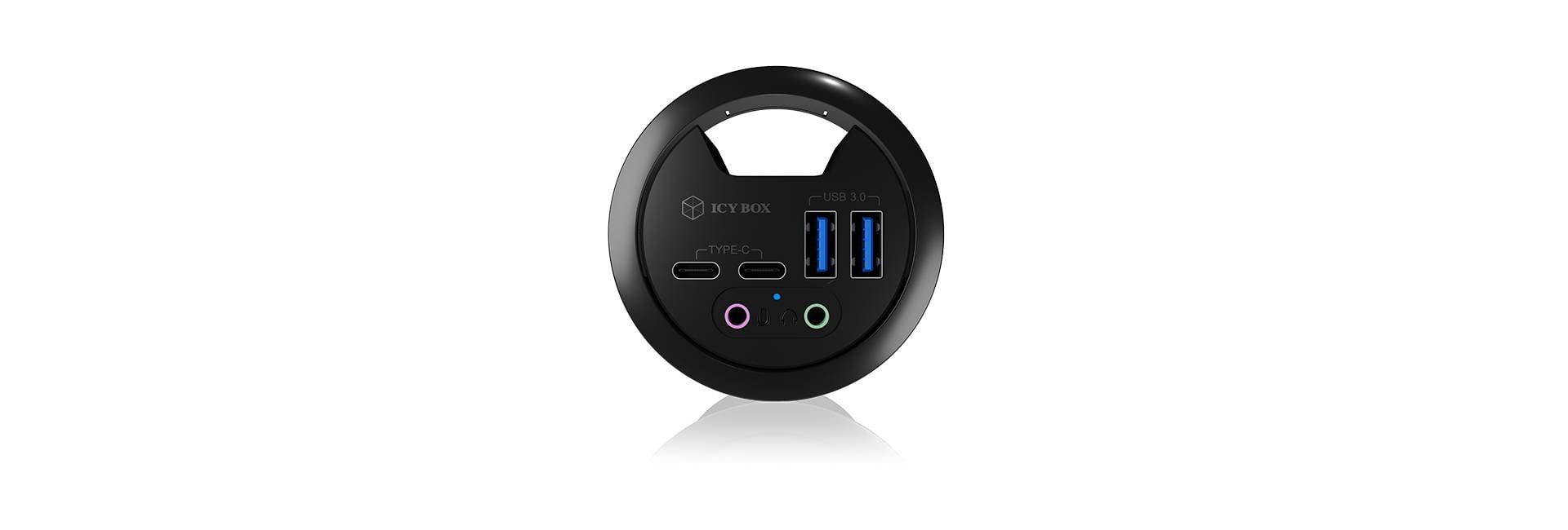 Crni, okrugli USB-hub s dva USB priključka, dvije okrugle audio utičnice i jednim USB-C priključkom.