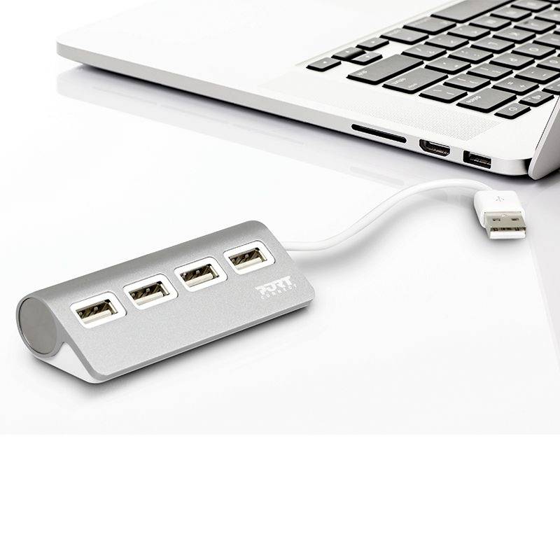 USB hub s tri USB priključka spojen je na prijenosno računalo koje stoji na bijelom stolu.