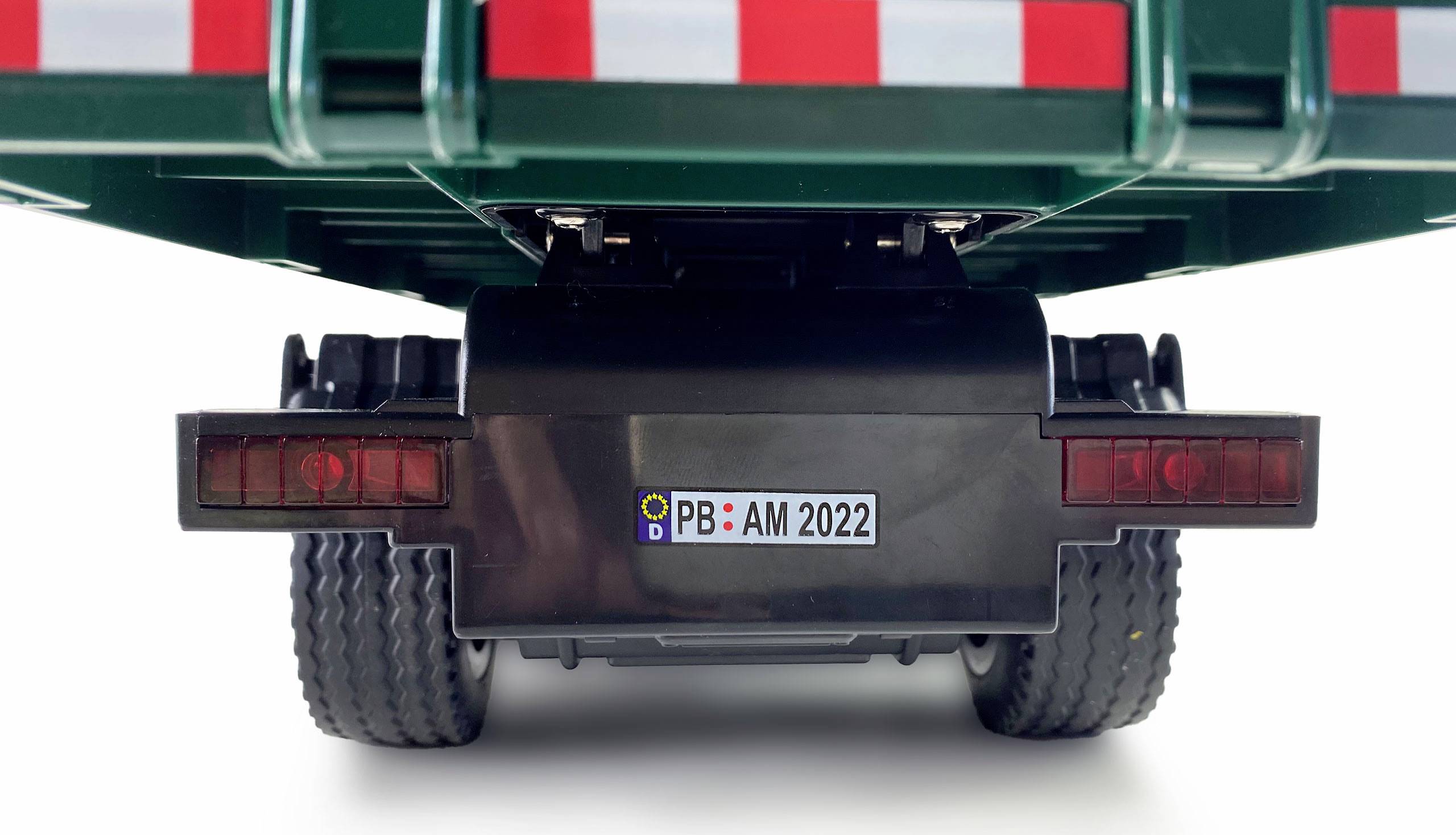 Donja strana igračke vozila s vidljivom registarskom oznakom 'PB AM 2022'. Stražnja svjetla i gume također su vidljivi.