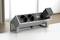 Višestruka utičnica s dvije utičnice i USB priključkom, postavljena na stolu. Pozadina je prostorija s prirodnim osvjetljenjem.