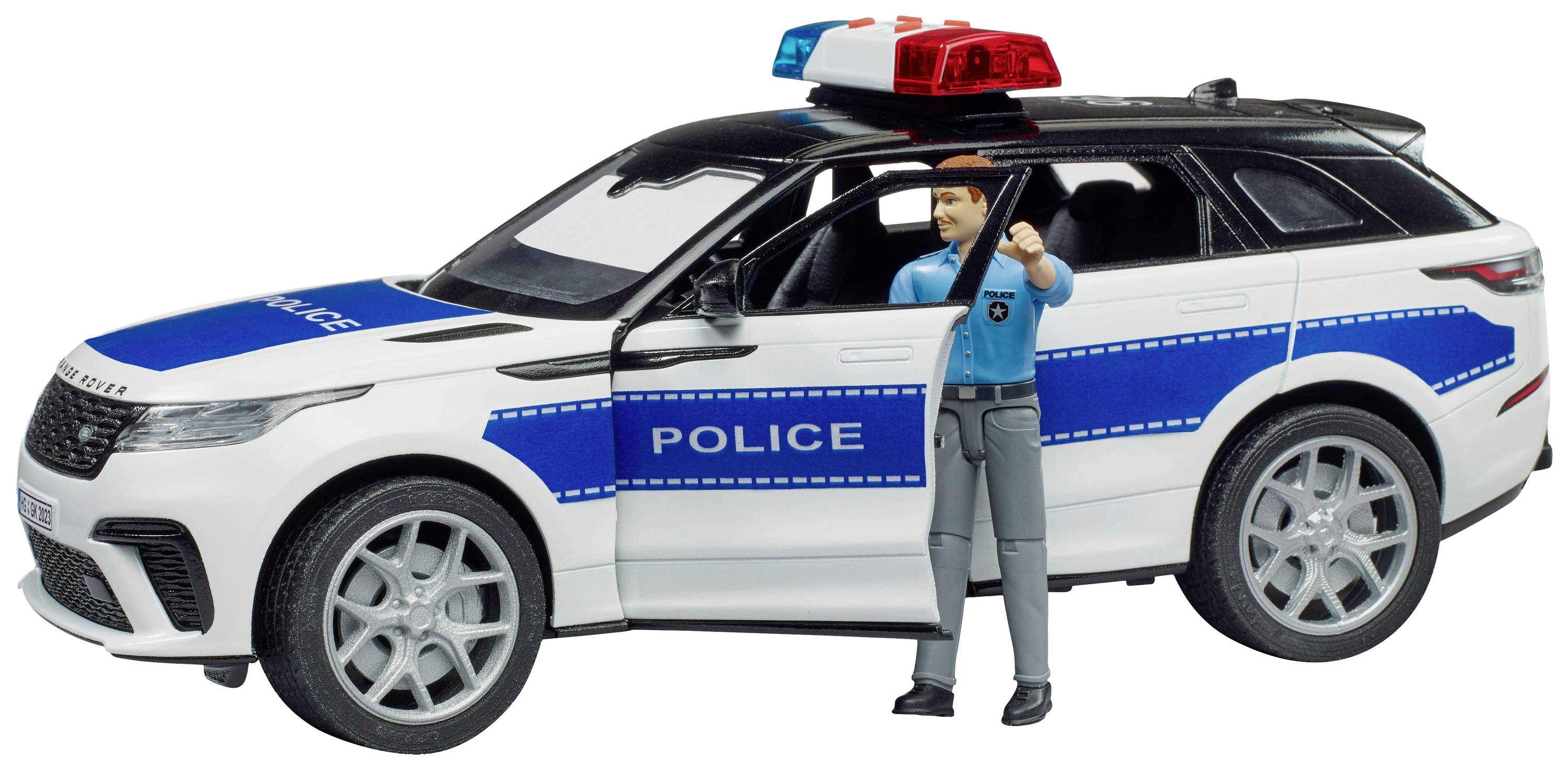 Igračka policijski automobil s policajcem u plavoj uniformnoj majici koji gleda kroz vrata vozača. Automobil je s plavo-bijelim prugama i rotacijskim svjetlima na krovu.