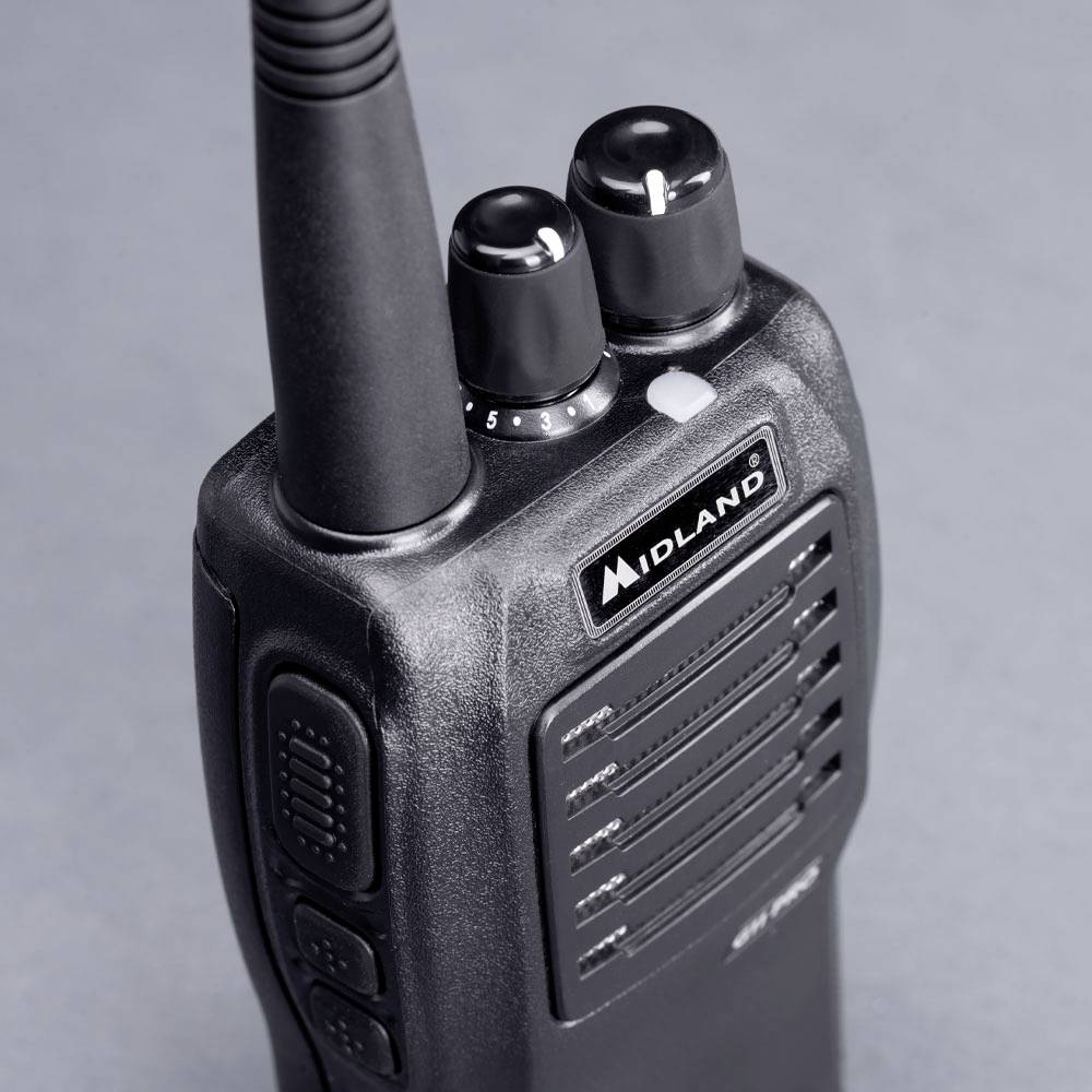 Crni radio uređaj s antenom i upravljačkim elementima na vrhu. Na prednjoj strani označen natpisom 'Midland'.