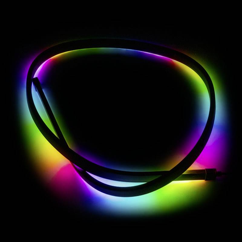LED-traka u sjajnim bojama leži na tamnoj podlozi. Boje se izmjenjuju i ravnomjerno svijetle.
