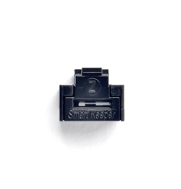 Crni, kvadratni poklopac USB porta s natpisom 'Smart Keeper' na bijeloj podlozi.