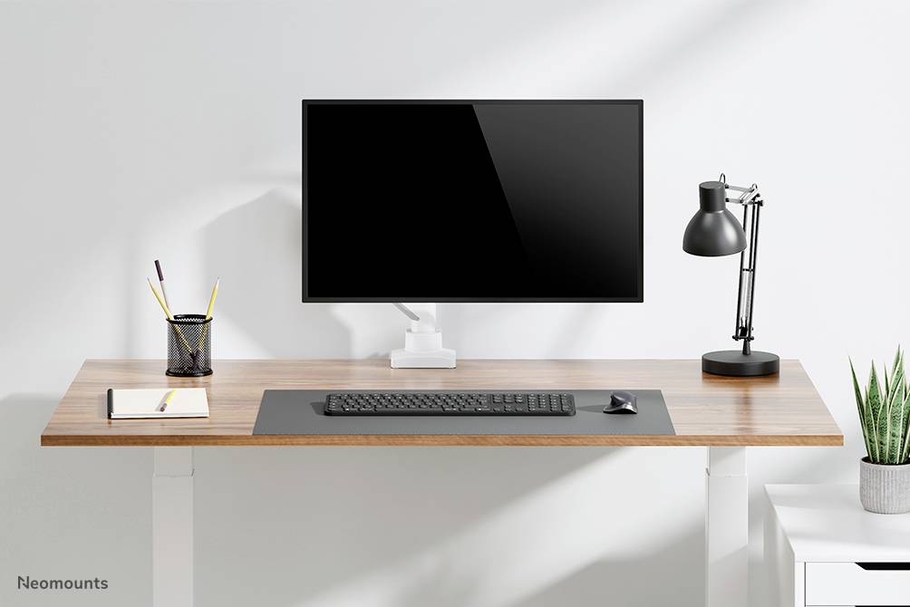 Radni stol s monitorom, tipkovnicom, lampom i posudom za olovke. Moderan i minimalistički dizajn.