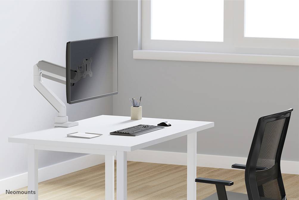 Moderan, minimalistički uređen radni prostor s monitorom na ruci, tipkovnicom, mišem, bilježnicom i posudom za olovke.