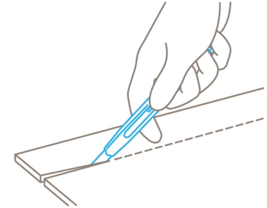 Jedna ruka reže duž isprekidane linije pomoću skalpela. Ravnalo se koristi za precizno vođenje reza.