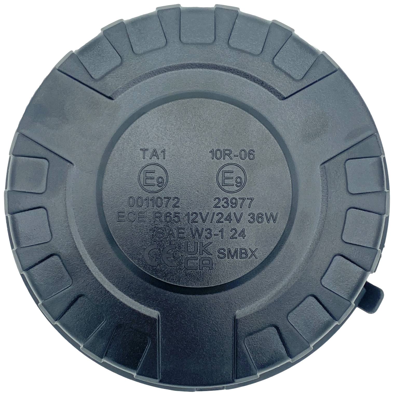 Okrugli crni predmet s istaknutim rubovima, s natpisima u sredini, uključujući 'ECE R65 12V 24V 36W'.