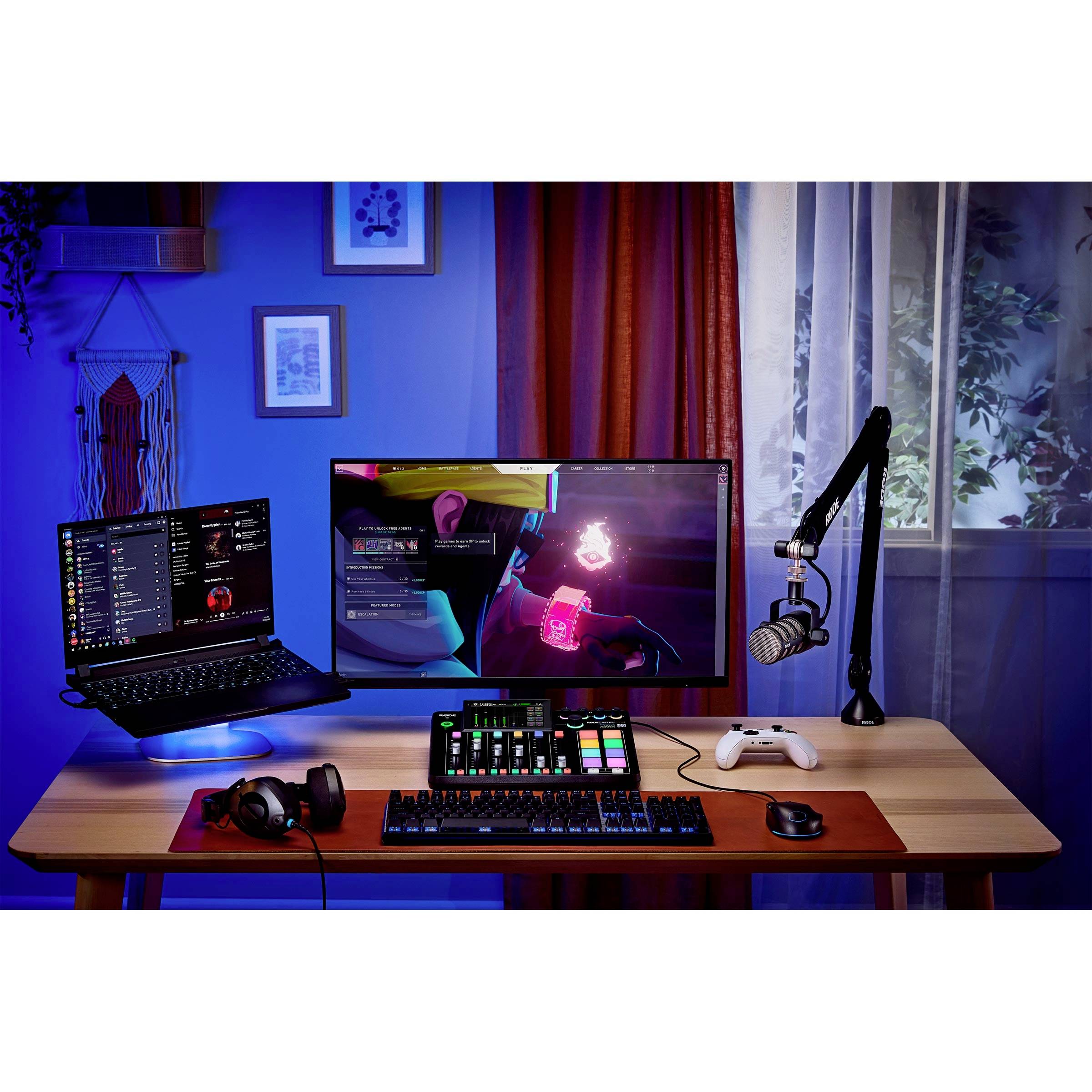 Radni stol s prijenosnim računalom, monitorom, streaming mikrofonom, slušalicama i kontrolerom. Pogodan za igranje ili kreativni rad.