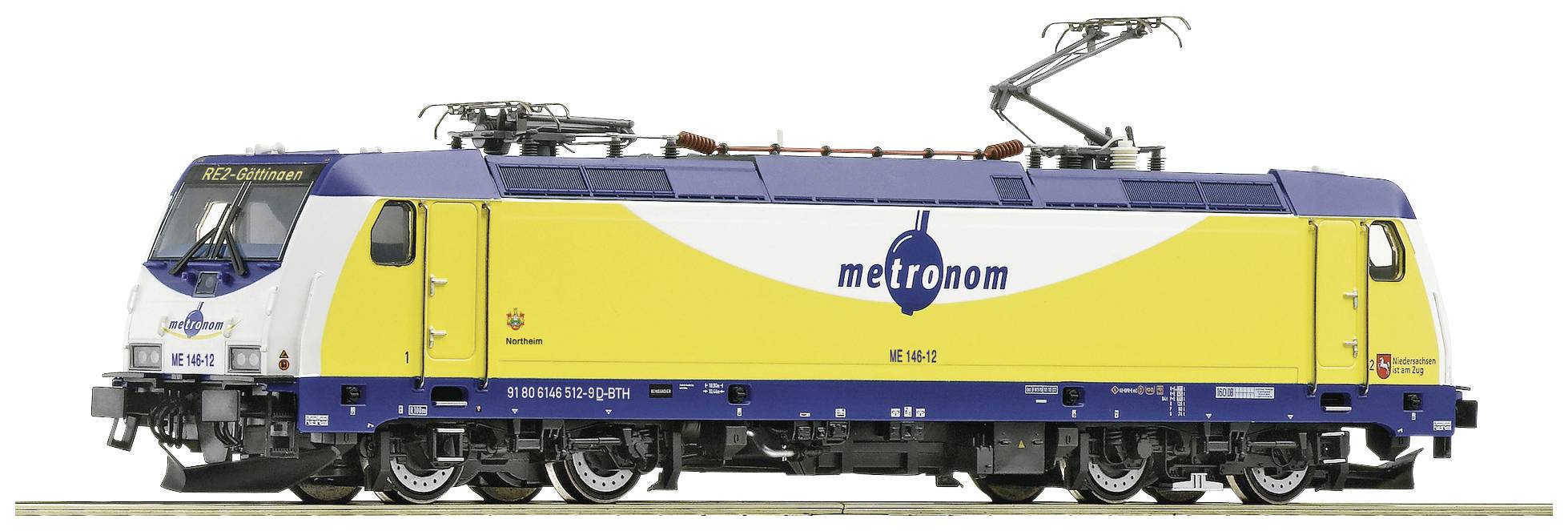 Žuto-plava električna lokomotiva Metronoma s logotipom tvrtke i nadzemnim vodovima. Stoji na dionici željezničke pruge.