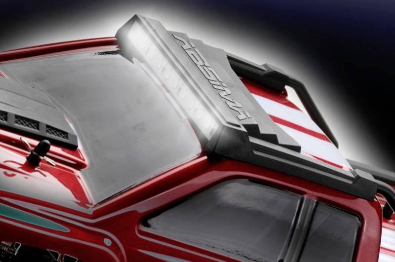 Bliski kadra crvenog modelnog automobila s detaljnim krovnim reflektorom. Automobil ima bijele pruge i crni krovni dodatak.