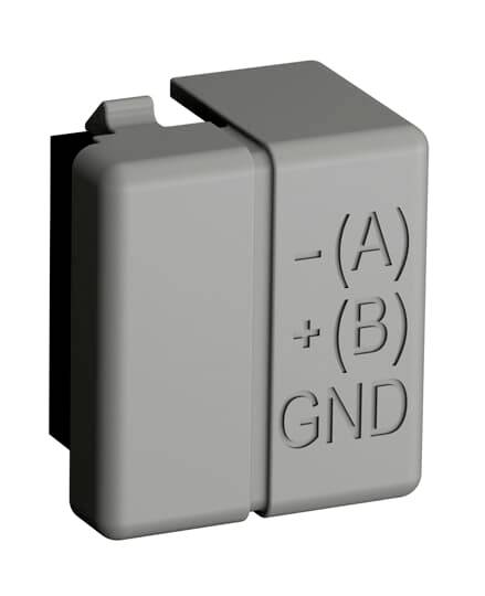 Sivi adapter s pisanom oznakom: '-(A) +(B) GND', pokazuje polaritet i uzemljenje.