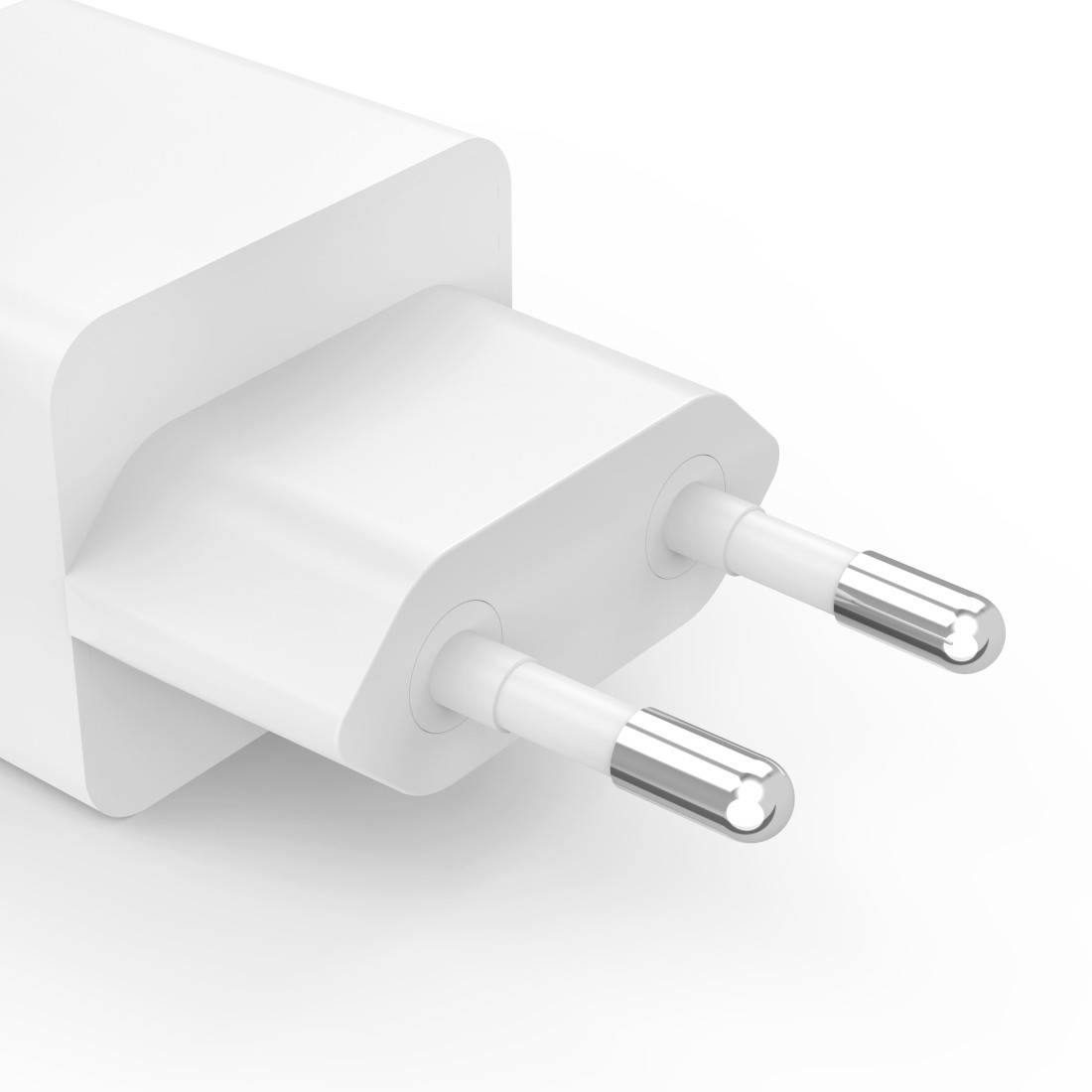 Bijeli USB punjač s dva Euro utikača, fotografiran iz kosa odozgo, pred neutralnom pozadinom.