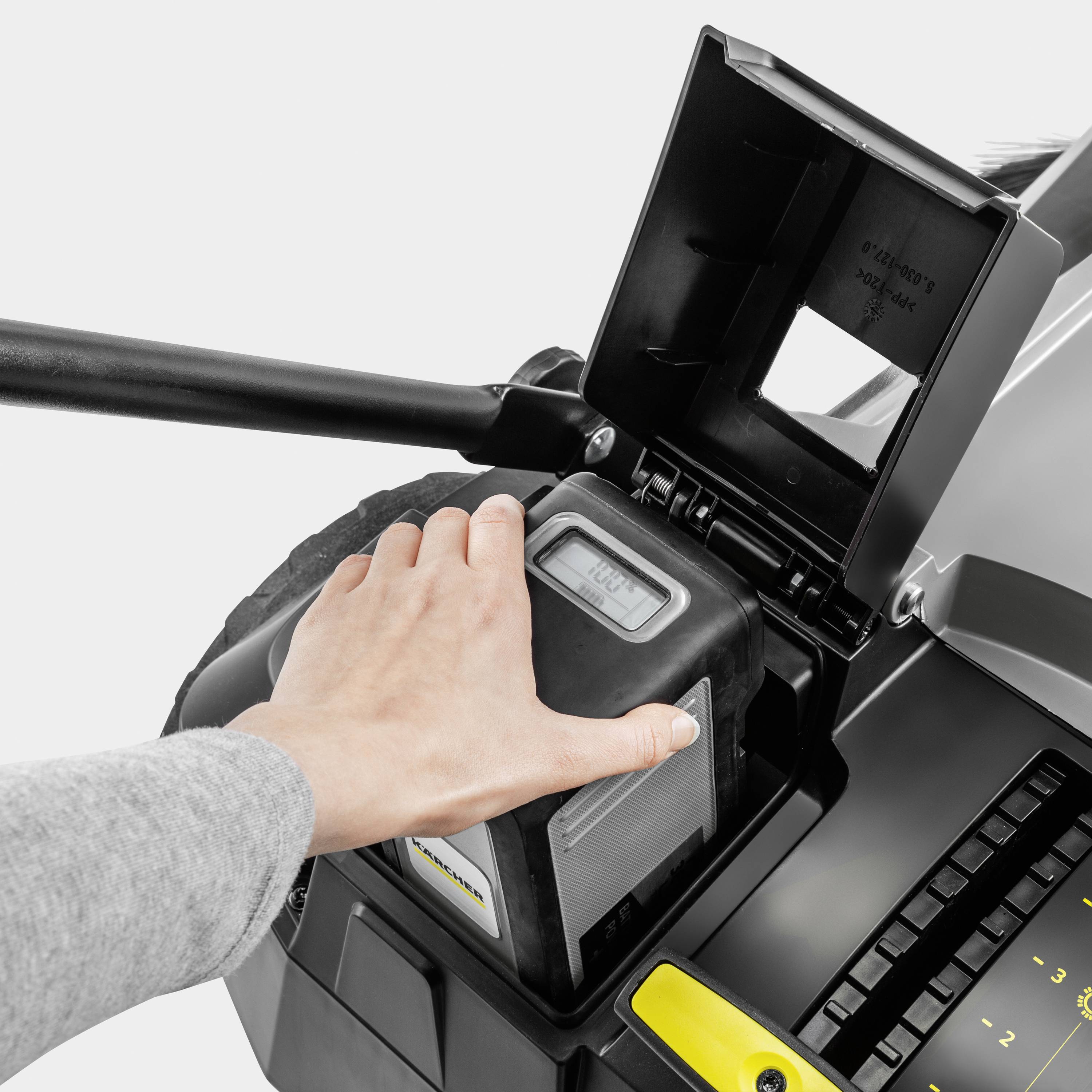 Ruka upravlja elektroničkom kontrolnom tipkom na stroju s digitalnim zaslonom i otvorenim spremištem.