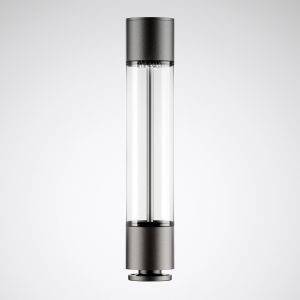 Moderna, cilindarska staklena boca s crnim poklopcima na oba kraja. Stoji vertikalno na sivoj podlozi.