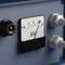 Analogni voltmetar pokazuje malo ispod 10 kV. Zaslon je dio plavog električnog uređaja s dvije okretne gumice.