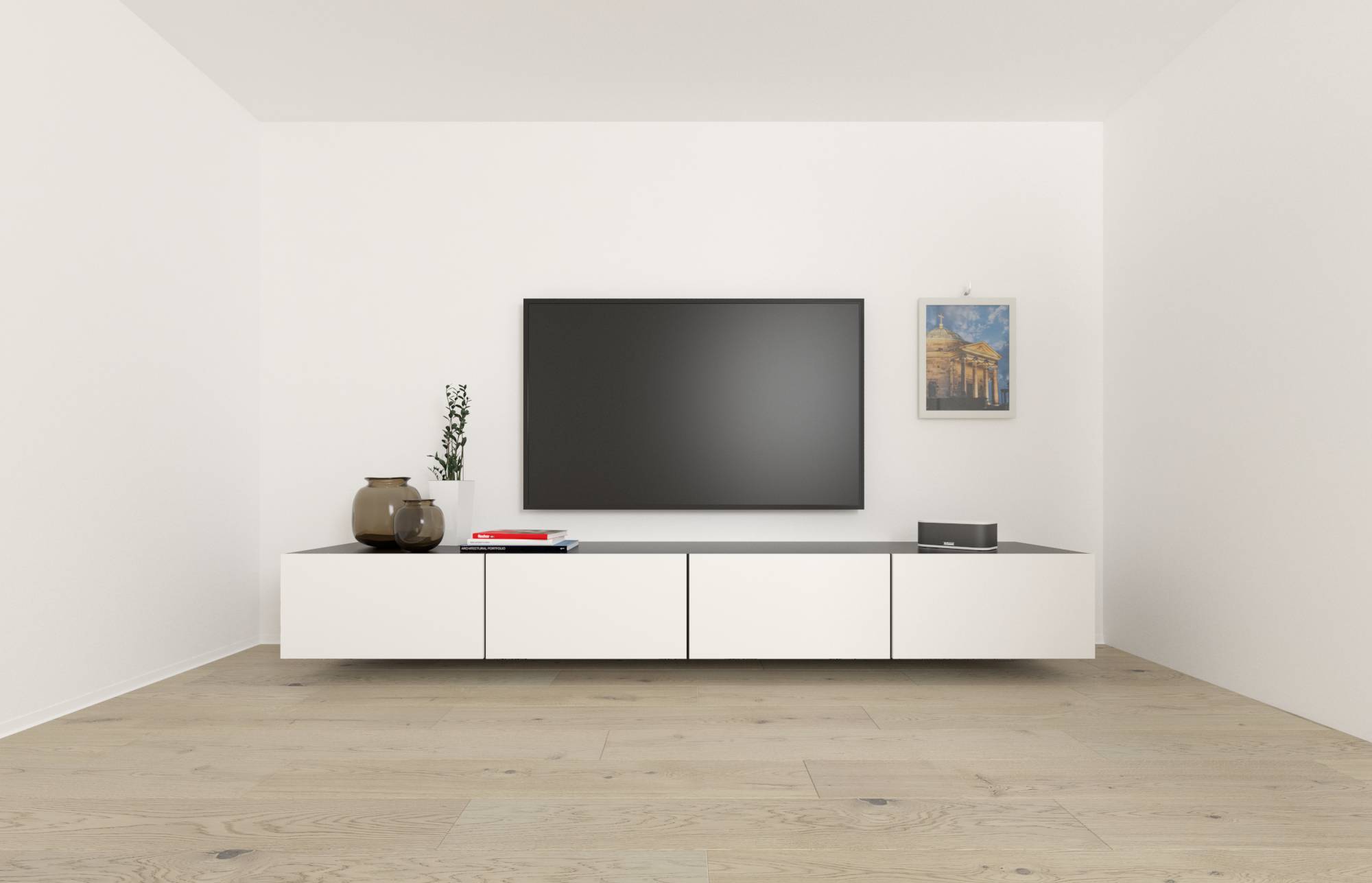 Minimalistična dnevna soba s velikim televizorom montiranim na zidu iznad bijele niske vitrине, vaze i knjige na lijevoj strani, te okvira sa sličkom na desnoj strani.