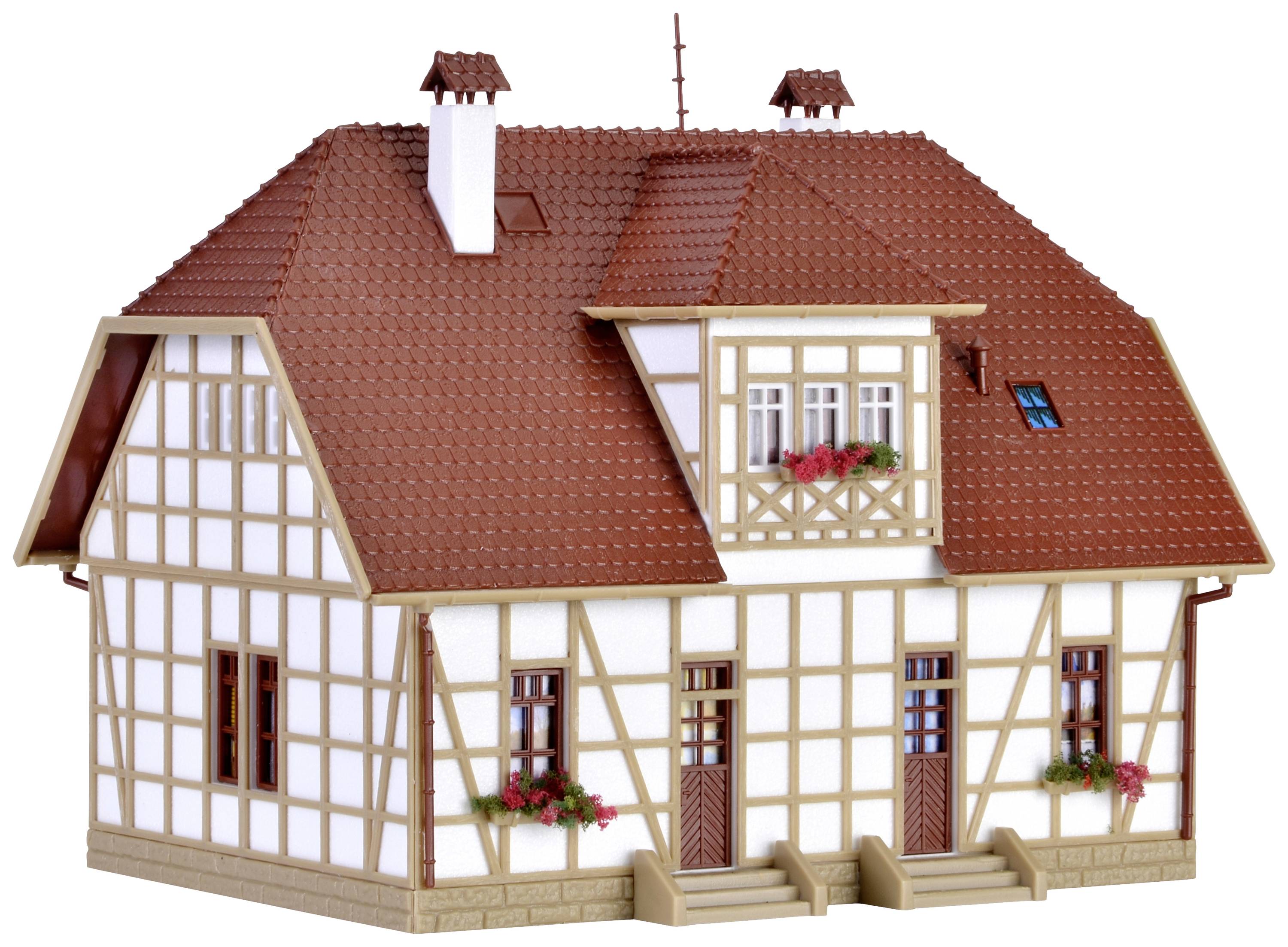 Model tradicionalne kuće s poprečnom drvenom konstrukcijom, crvenim krovovima, cvijećem na prozorima i nekoliko ulaza.