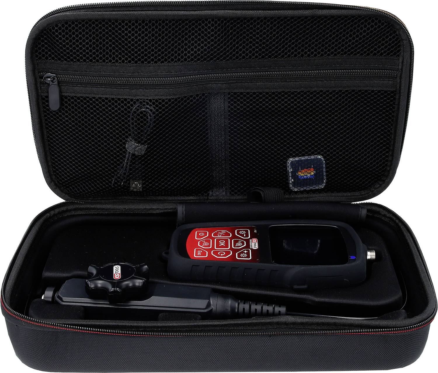 Dijagnostički uređaj s crvenim tipkama smješten je u crnu torbu s patentnim zatvaračem. Torba ima mrežastu džepu na vrhu.