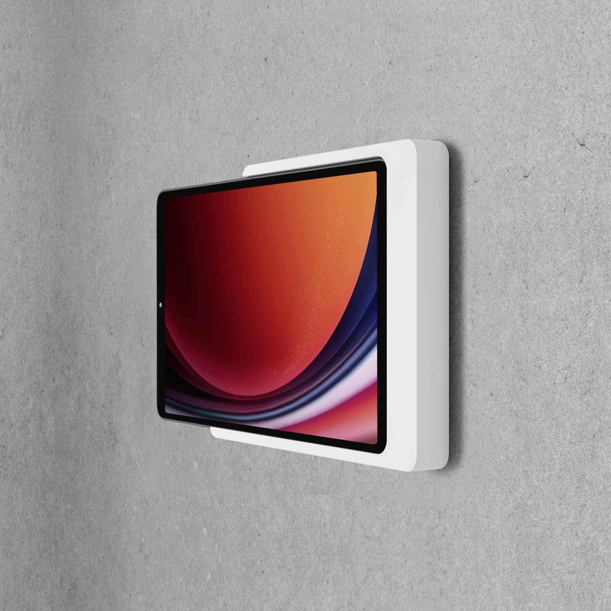 Tablet s crvenim zaslonom, montiran na sivoj stijeni. Zaslon prikazuje apstraktni uzorak s tekućim linijama.