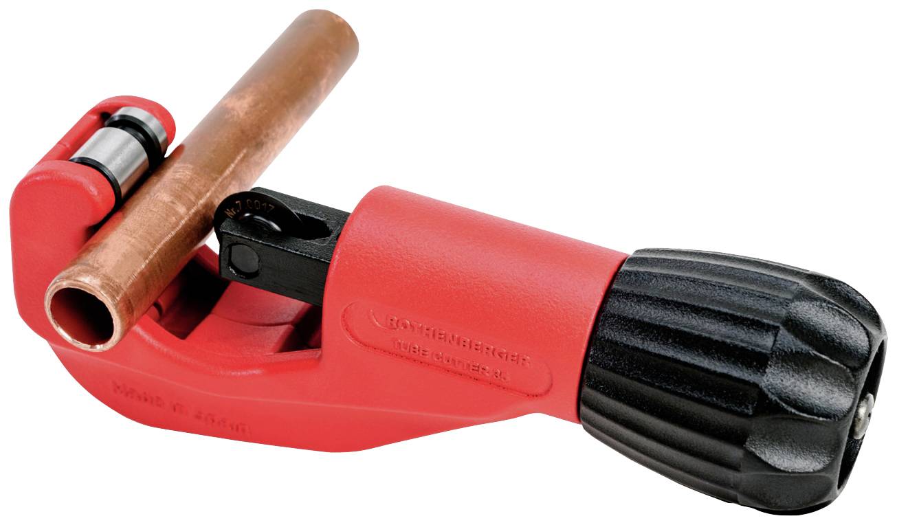 Crveni rezač cijevi s crnom ručkom drži bakrenu cijev.