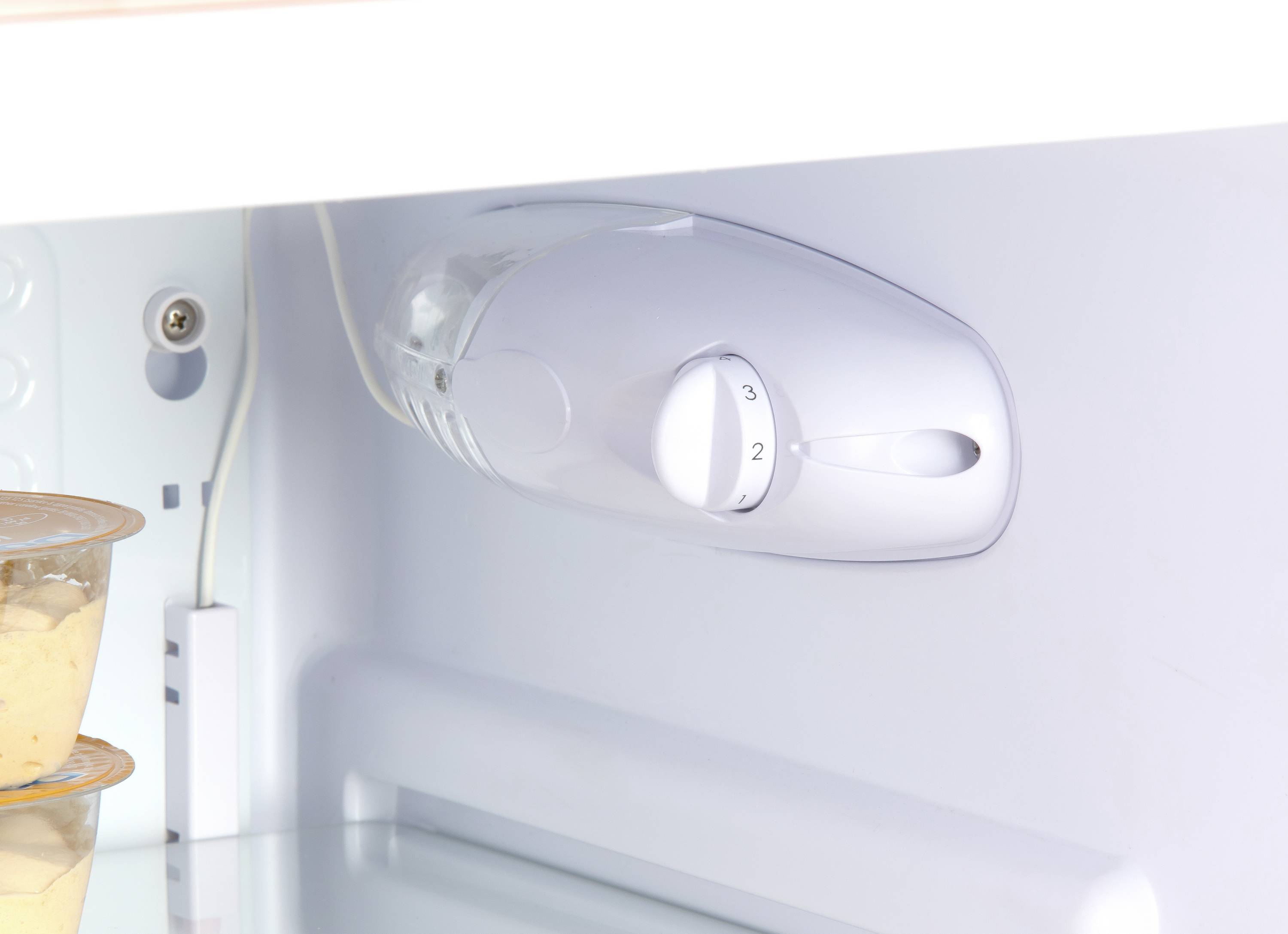 Unutrašnjost hladnjaka s bijelim regulatorom temperature postavljenim na razinu 2, pored kojeg se nalaze otvoreni jogurt lonci.