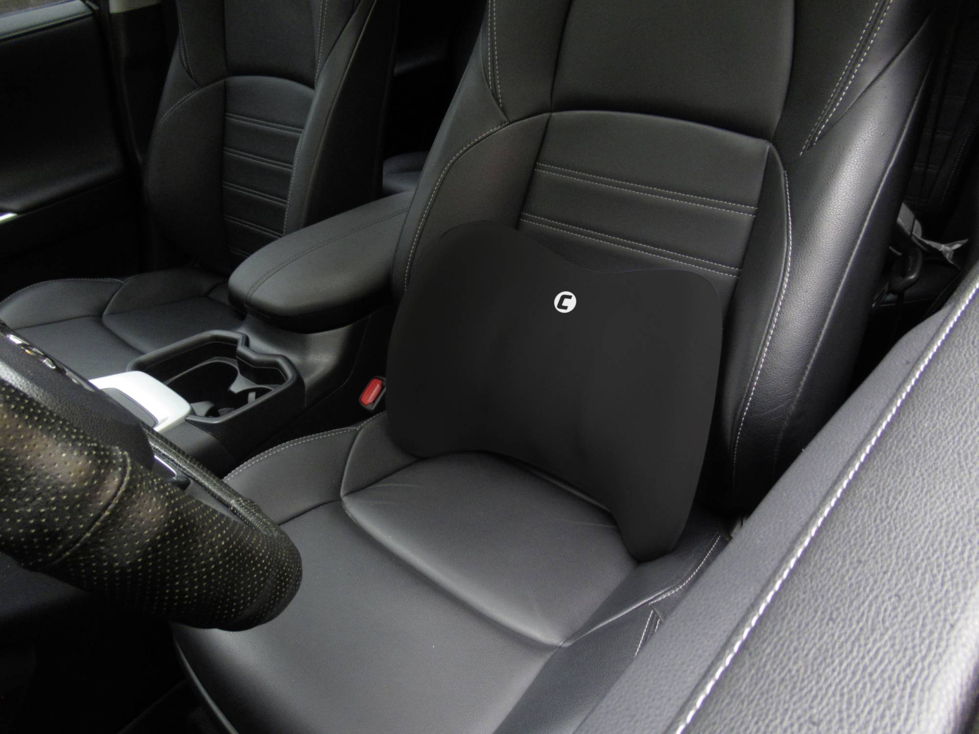 Autosjedalica s crnim pojasnim jastukom u izgledu kože za potporu donjeg dijela leđa. Sjedalo suvozača u modernom unutarnjem prostoru.