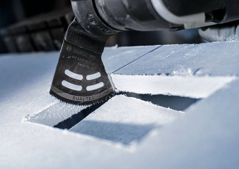 'Bliski kadar višenamjenskog alata s listom pile koji precizno reže bijeli materijal. Jasni rubovi i detalji vidljivi.'