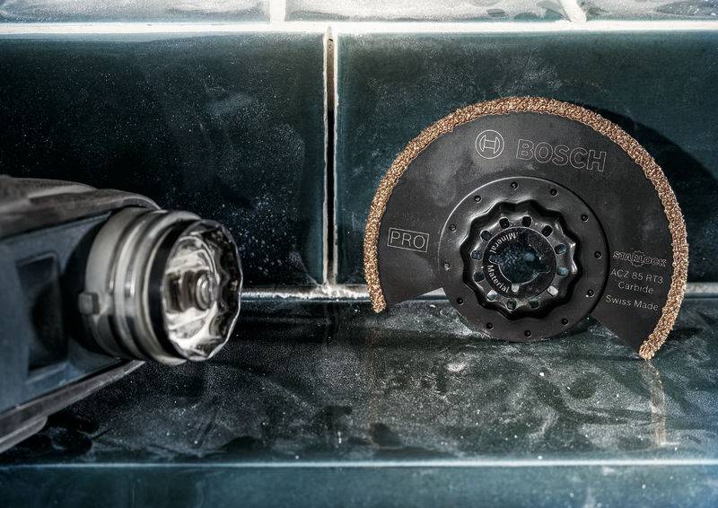 Električni alat s brusnim kotačem na pločičkoj površini. Brusni kotač ima natpis 'BOSCH PRO' i pogodan je za rezne radove.