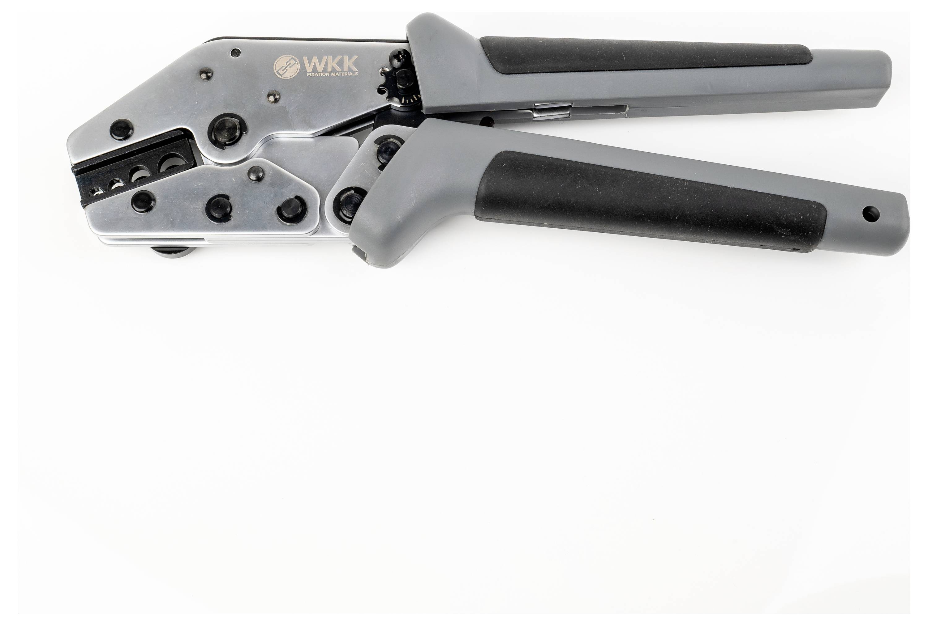 Krimpaljka sa sivim ručkama i nekoliko metalnih komponenti.