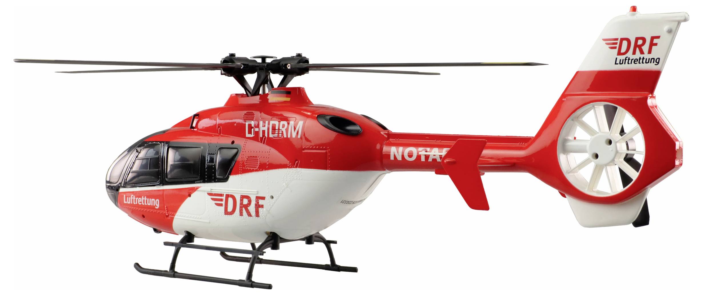 Helikopter za hitnu pomoć crveno-bijele boje DRF Luftrettung-a s natpisima 'NOTARZT' i 'DRF' prikazan je s bočne strane.