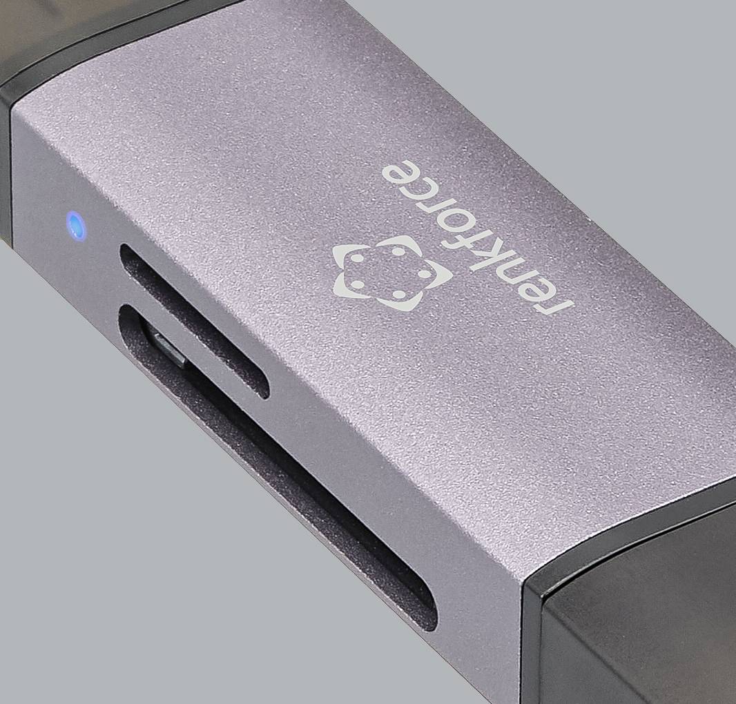 Srebrni čitač kartica marke 'Renkforce' s USB priključkom i jednom SD-karticom, na sivoj pozadini.