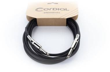 Crni audio kabel s metalnim priključcima, organiziran u krug, prikazan u smeđoj ambalaži na kojoj piše 'Cordial elements'.