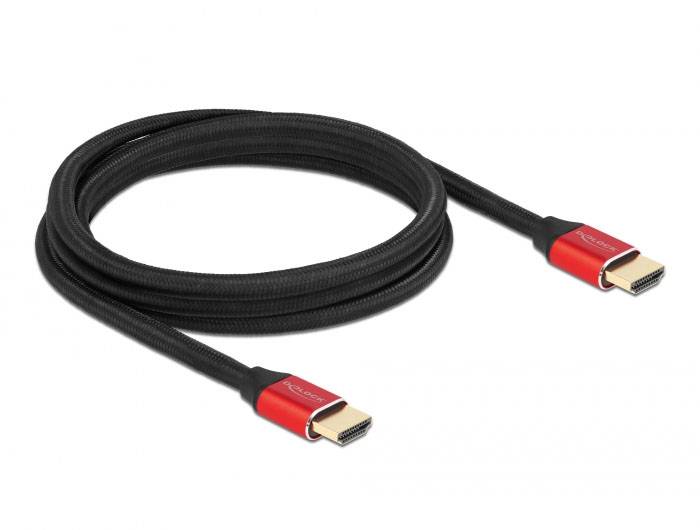 Crni HDMI kabel s crvenim utikačima na oba kraja, položen na bijeloj površini.
