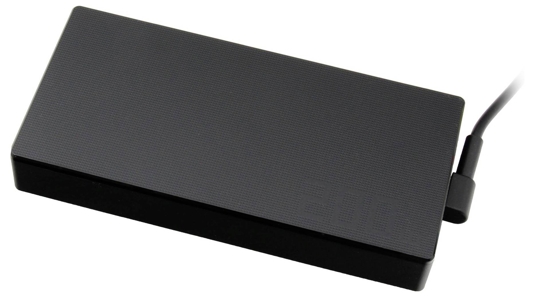 Crni vanjski USB punjač leži na površini, s priključenim kabelom na desnoj strani.