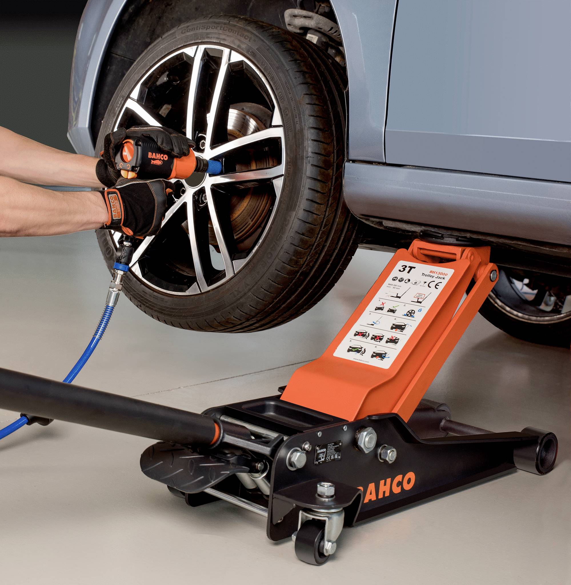 Jedna osoba mijenja auto gumu uz pomoć dizalice i pneumatskog ključa.