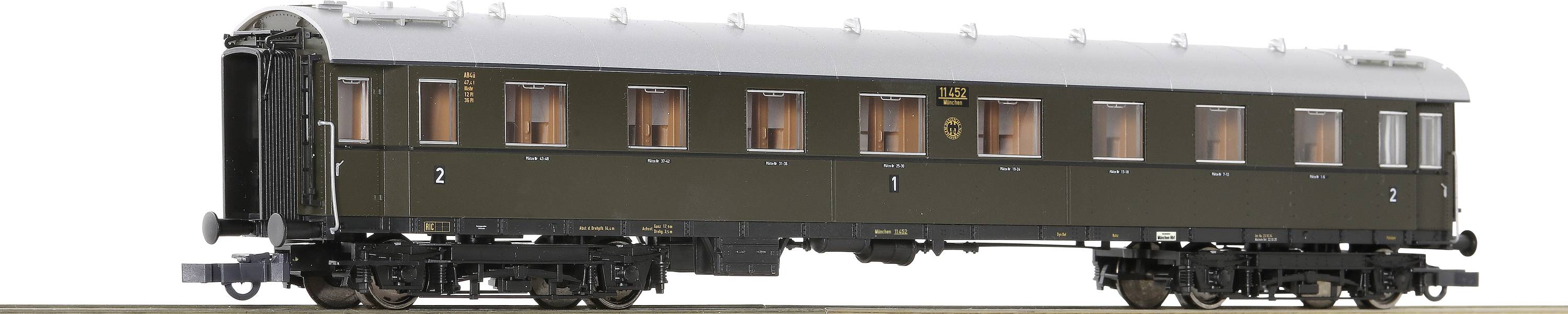 Model povijesnog zelenog željezničkog vagona sa smeđim krovom, osvjetljenim prozorima i detaljnim potklopcem.