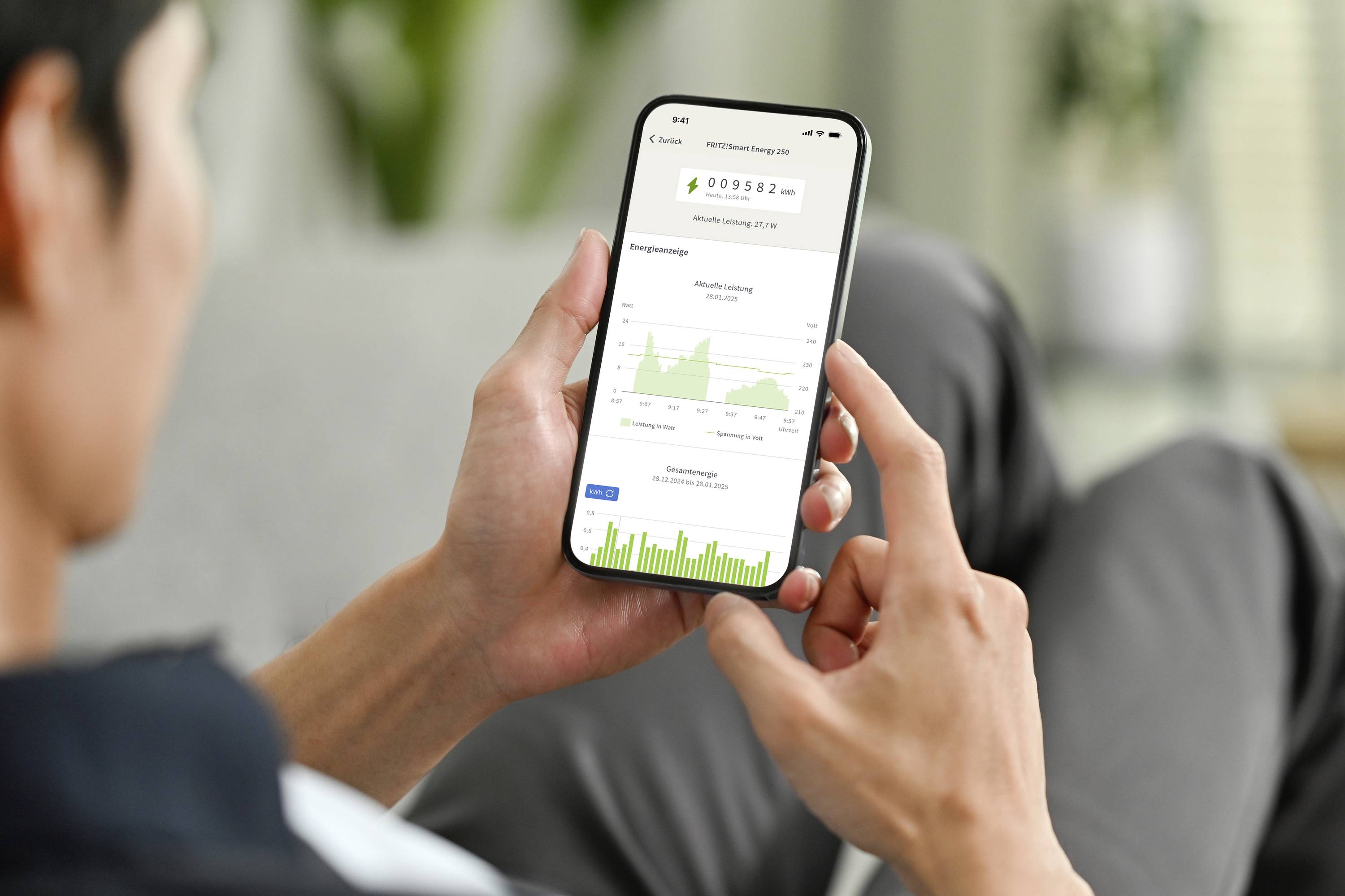 Jedna osoba drži pametni telefon s aplikacijom koja prikazuje grafove i statistike. Podaci se vjerojatno odnose na fitness ili zdravlje.