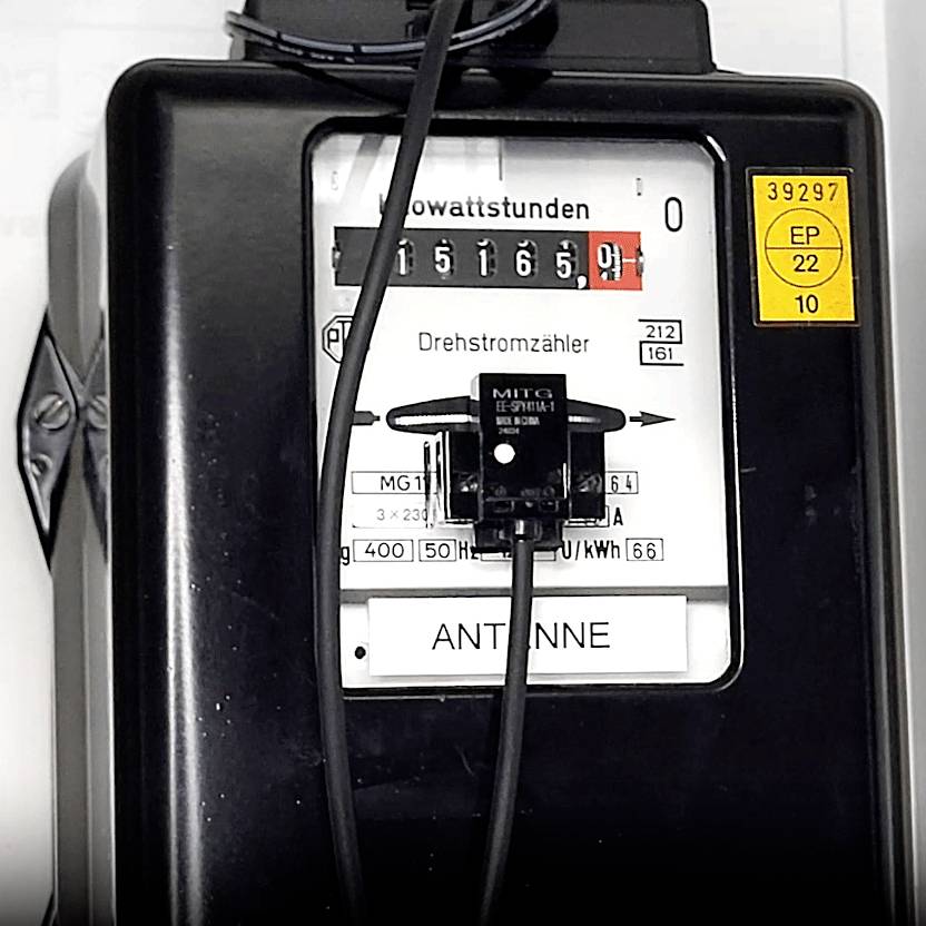 Stari električni brojač s mehanizmom brojanja i indikatorom trofazne struje. Uređaj prikazuje trenutačnu potrošnju kilovatsati. Antena je priključena.