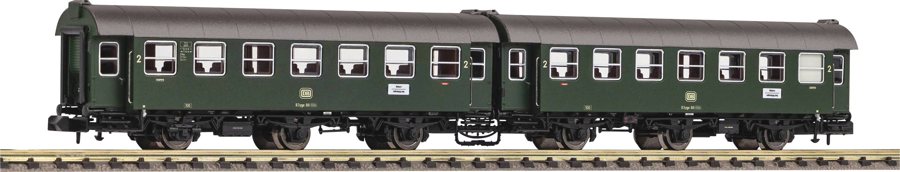 Dva zelena putnička vagona na željezničkim modelarskim tračnicama. Vagoni imaju klasičan dizajn s nekoliko prozora i detaljnim podvozjem.