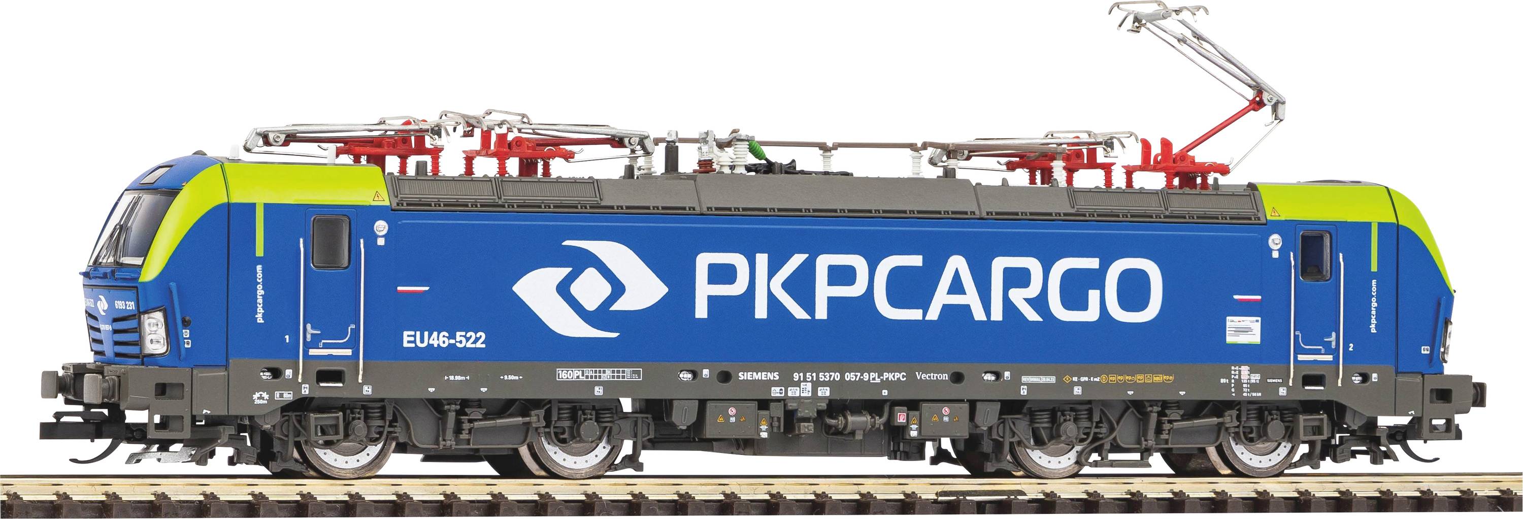 Plava lokomotiva s natpisom 'PKP CARGO' vozi po tračnicama. Lokomotiva ima zelenu i crvenu dekoraciju na vrhu.