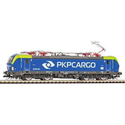 Plava lokomotiva s natpisom 'PKP CARGO' vozi po tračnicama. Lokomotiva ima zelenu i crvenu dekoraciju na vrhu.