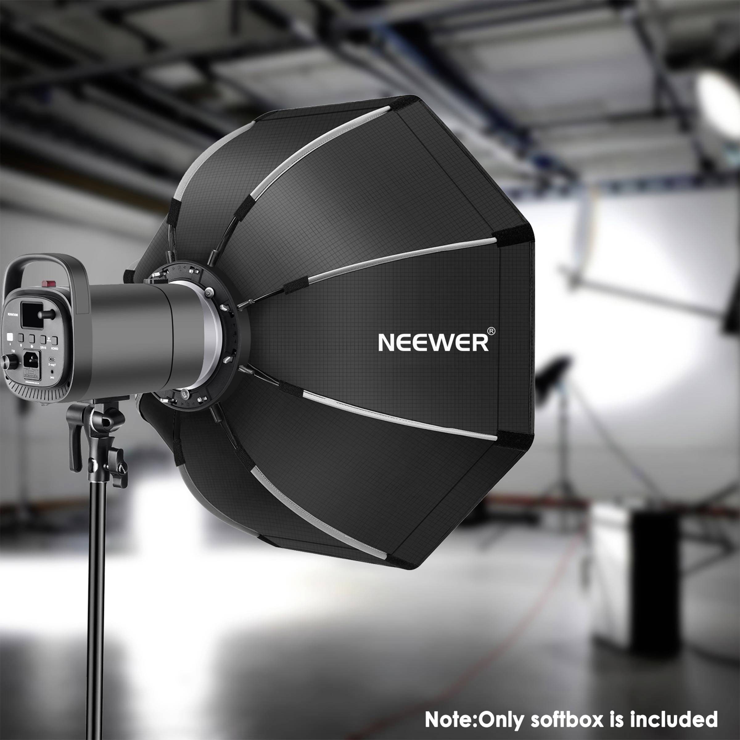 Studijska softbox lampa marke 'NEEWER' na stalku, okružena nejasnom studio opremom u pozadini.