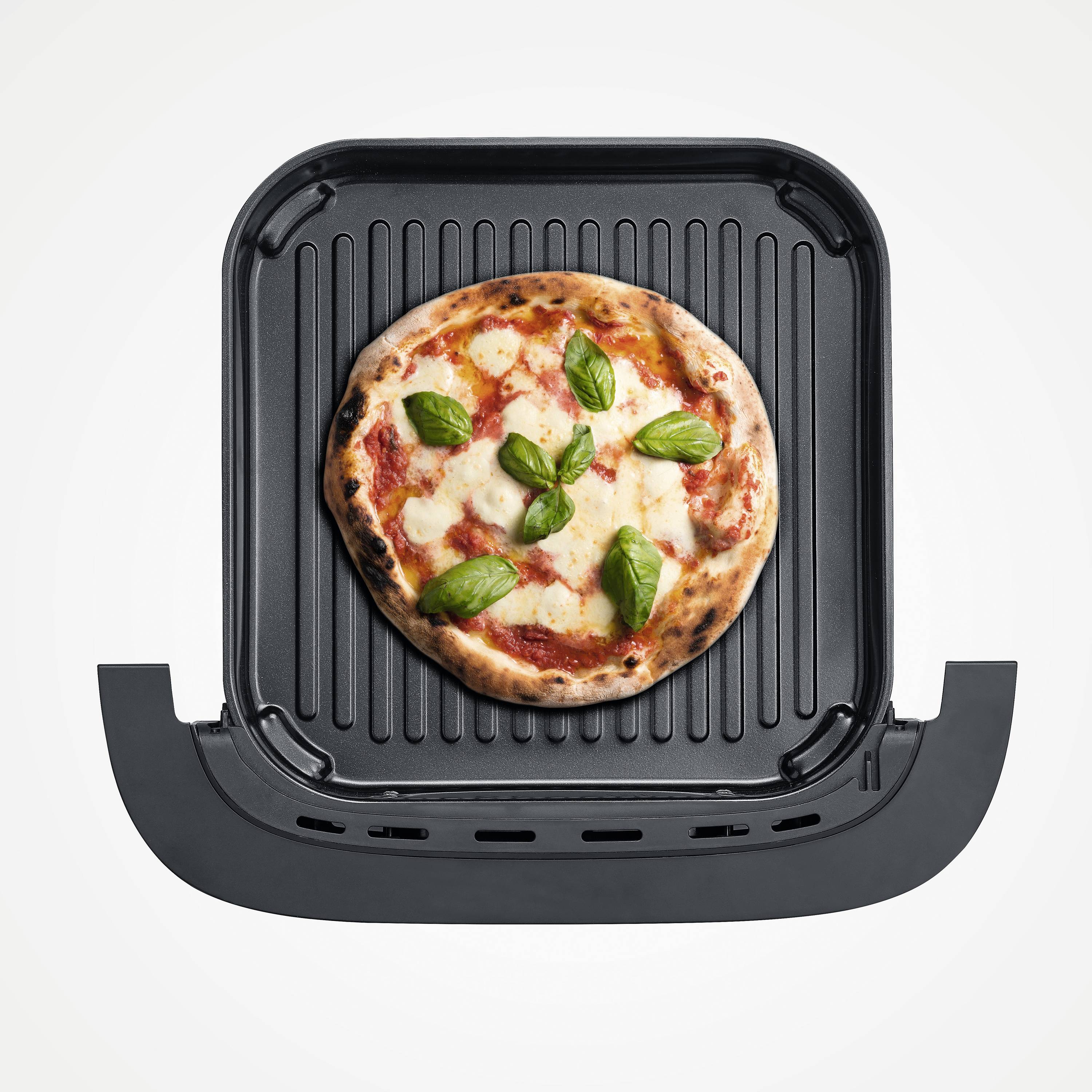 Pizza s umakom od rajčice, mozzarellom i listovima bosiljka na grill ploči.
