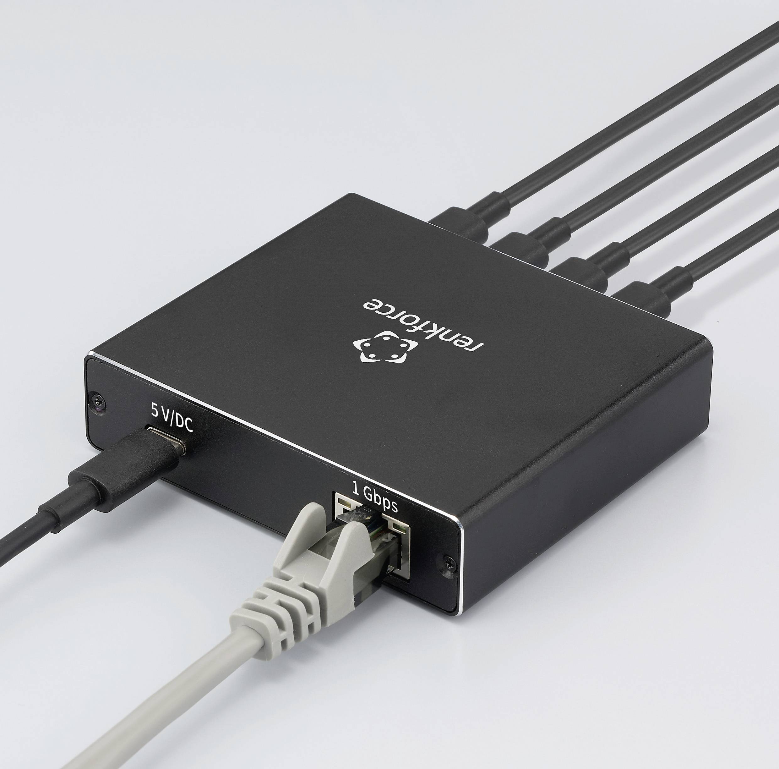 Crni mrežni switch oznake 'Telkforce' s priključcima za '5 VDC' i '1 Gbps', povezan several kabelima, koji ukazuju na prijenos podataka.