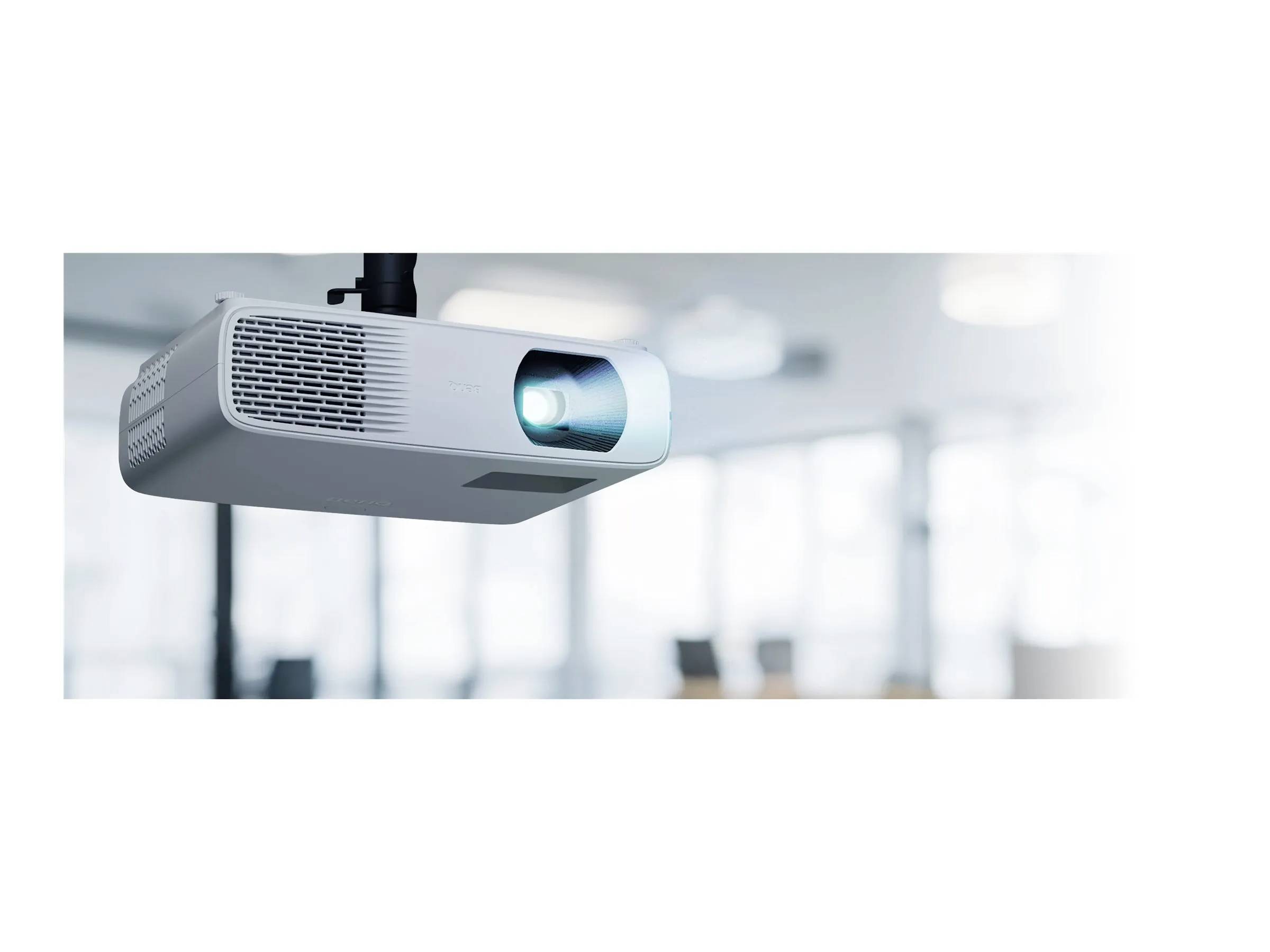 Projektor montiran na stropu je aktivan, projicira plavo svjetlo u svijetlom uredu s zamućenim elementima pozadine.