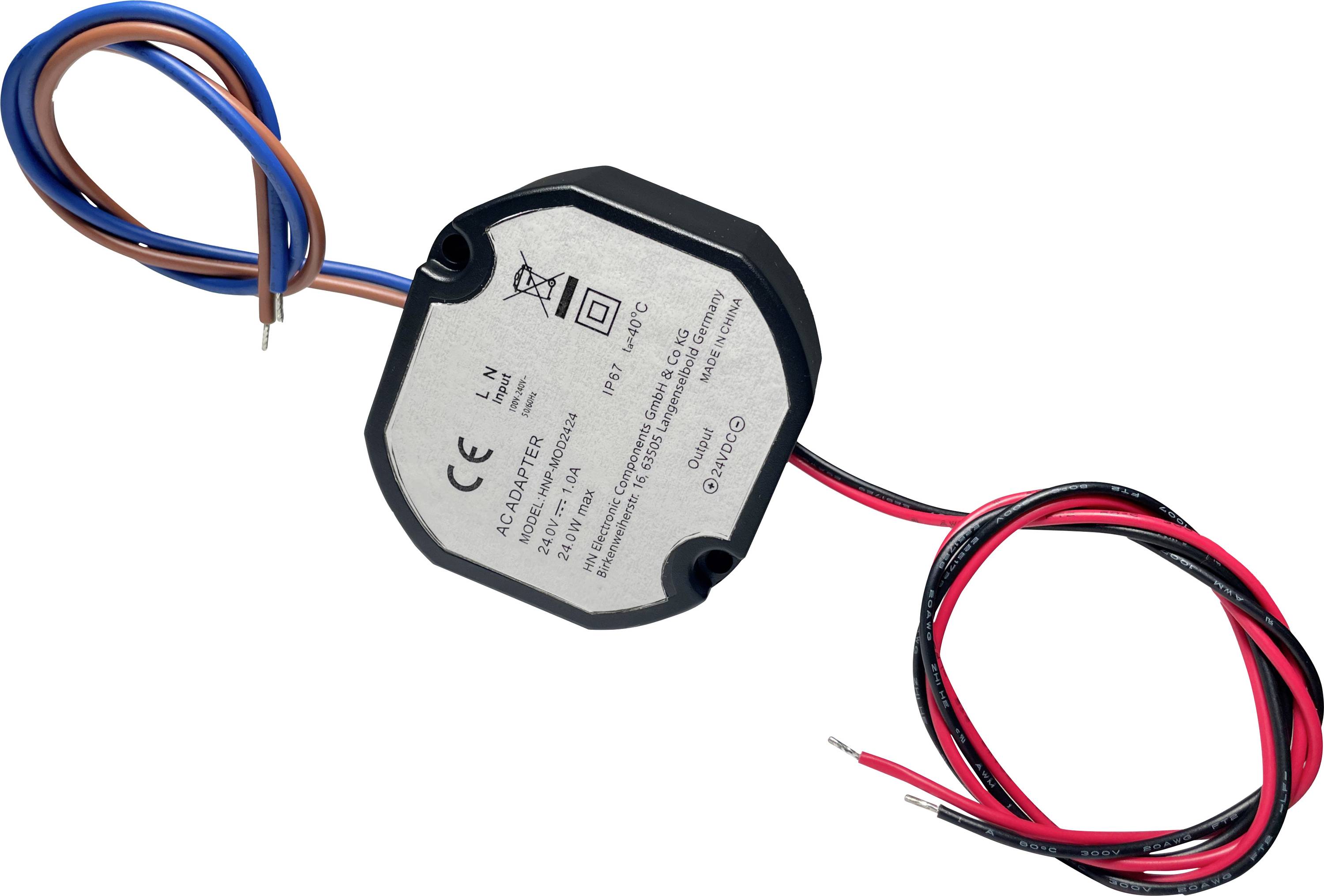 Mali heksagonalni AC adapter s specifikacijama ulaza/izlaza otisnutim na vrhu, koji ima plavo/smeđe ulazne žice i crveno/crne izlazne žice.